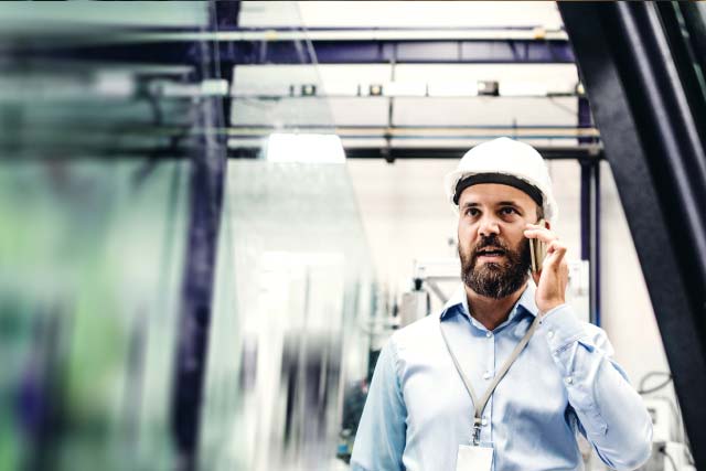 Man wearing safety helmet talking over the phone
