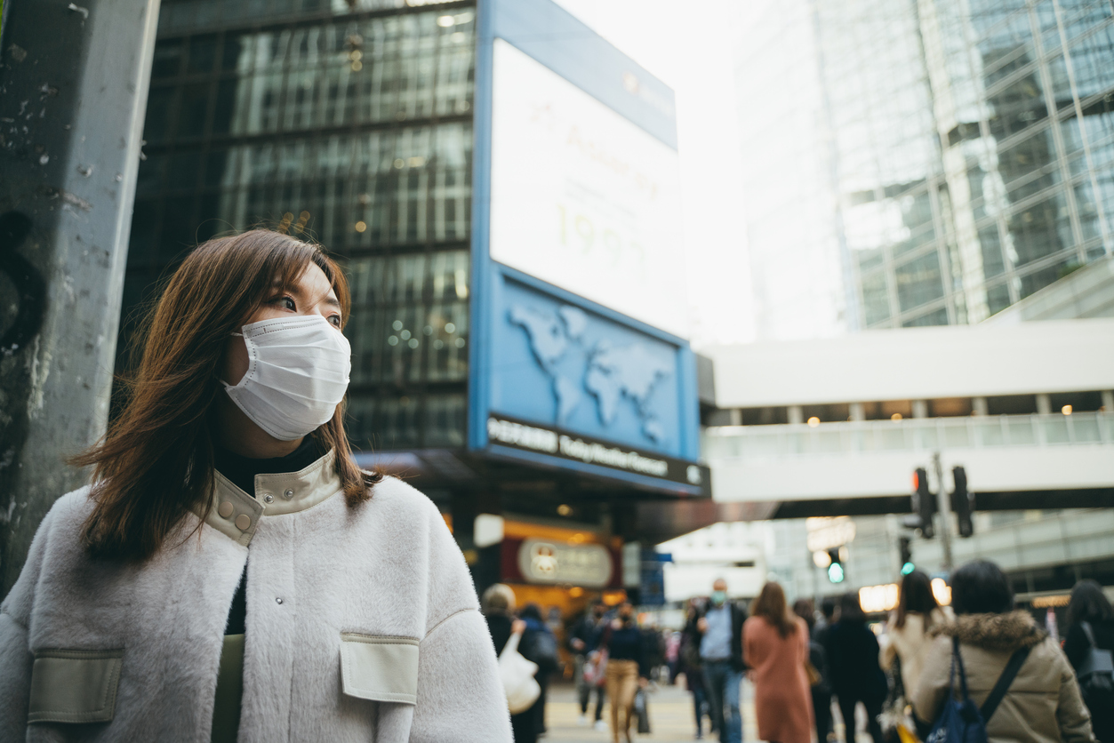 a woman in city wearing a mask