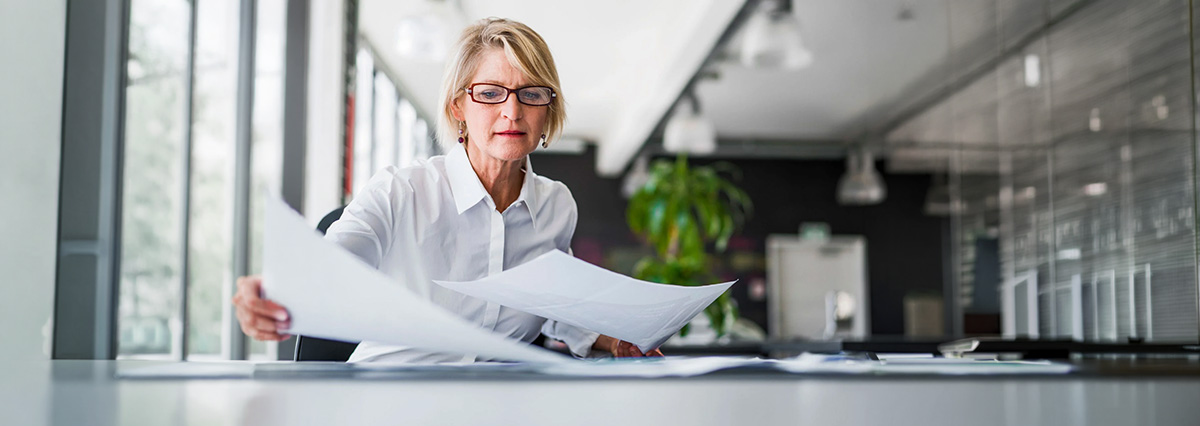 A woman is organizing paper reports