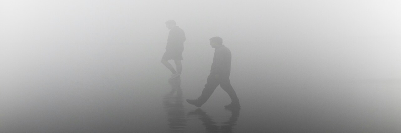 people walking in the fog