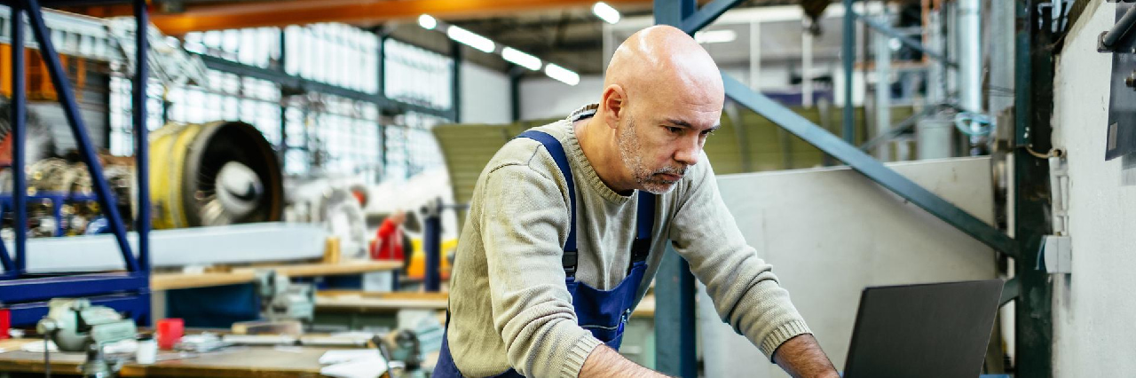 man using laptop in factory hero