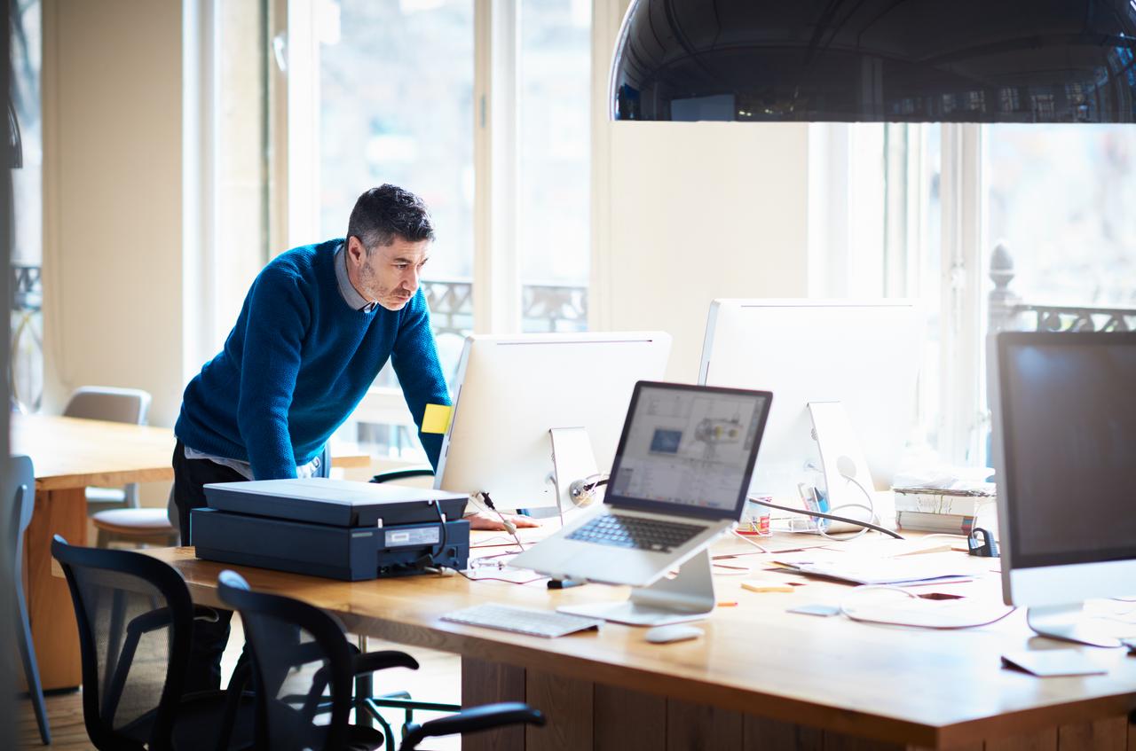 man leaning forward looking at computer