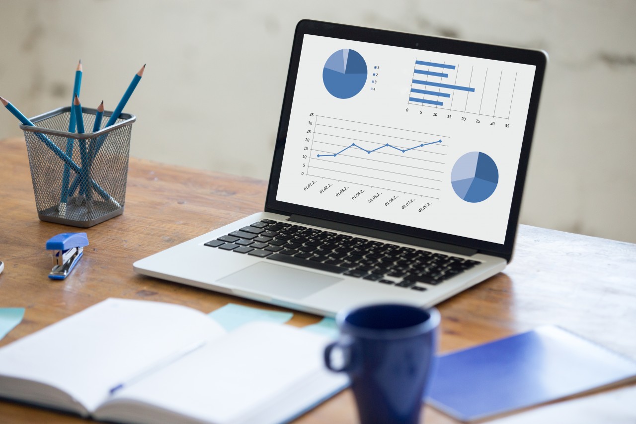 open laptop with pie graph and line graph on it