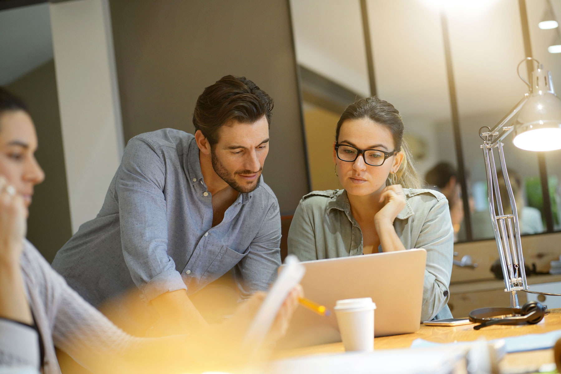 co-workers intensely looking at laptop together