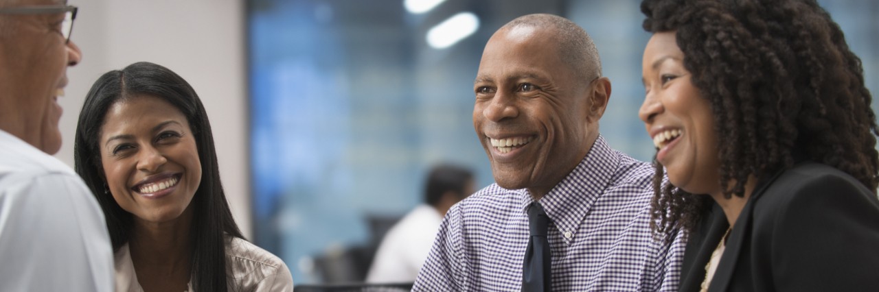 three people smiling in a meeting