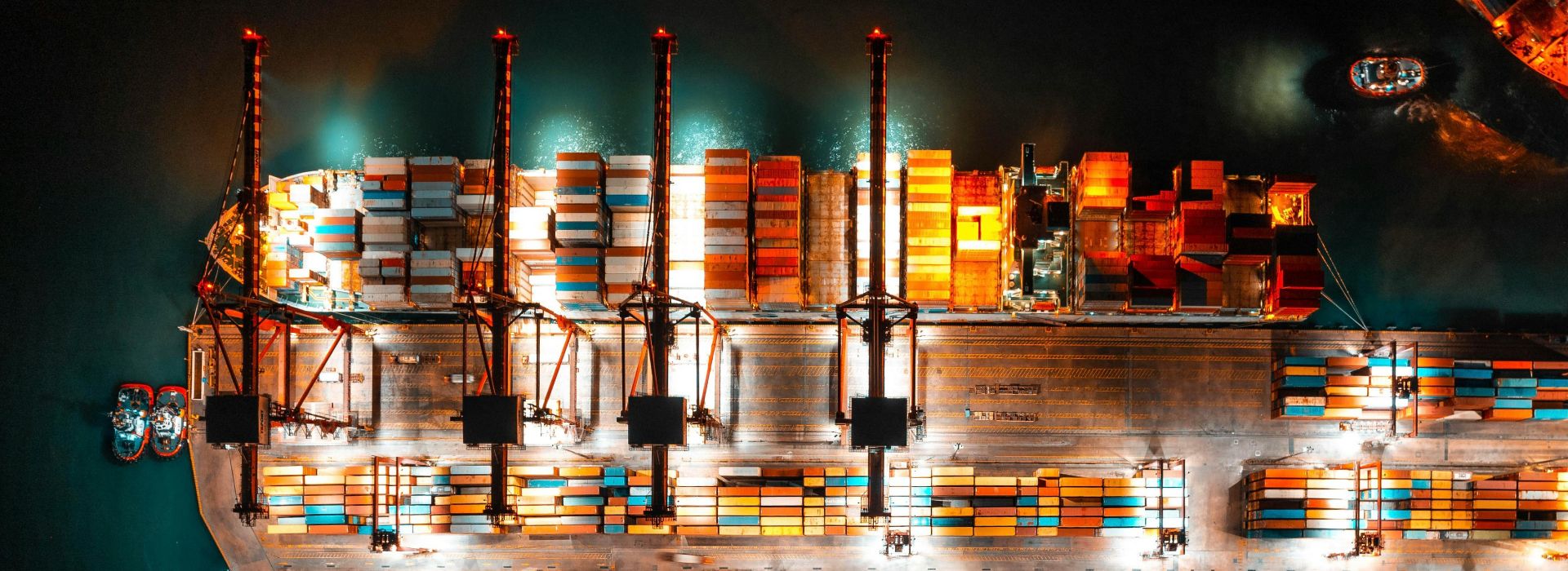 Molo di un porto commerciale con container di merci visto dall'alto, di notte