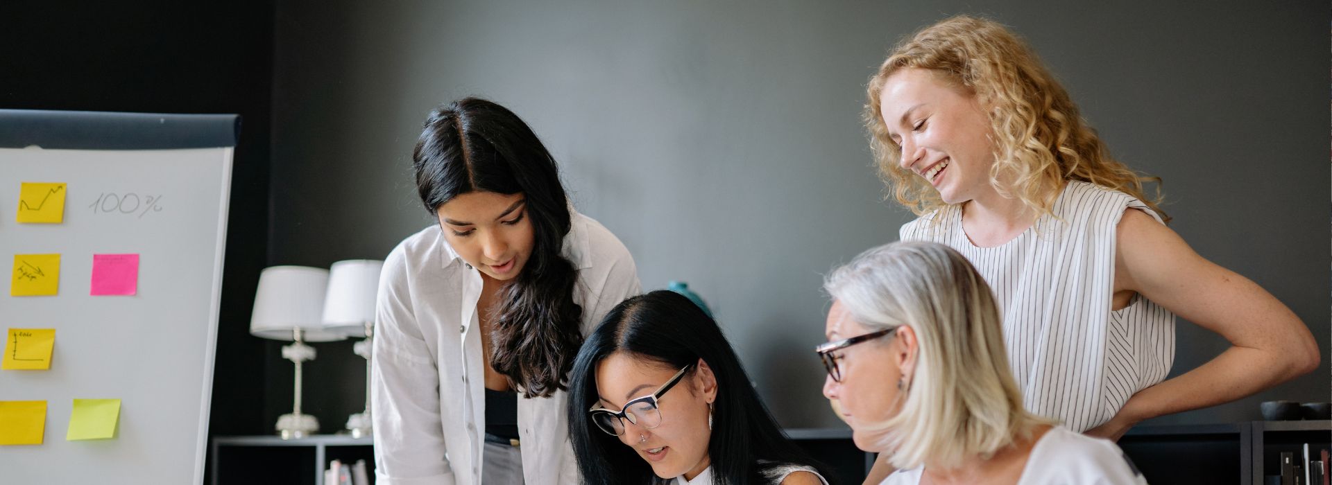 tre donne lavorano insieme in sala riunione