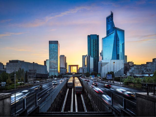 Skyline moderno al tramonto, con grattacieli in vetro che riflettono luce dorata
