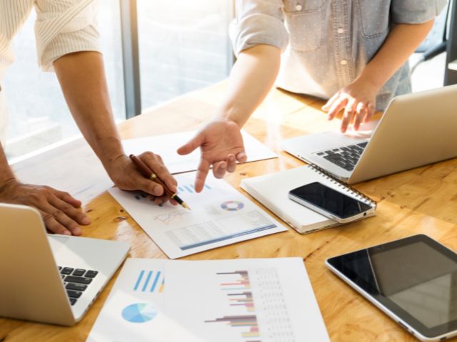 Analisi economica con grafici e laptop su tavolo di lavoro