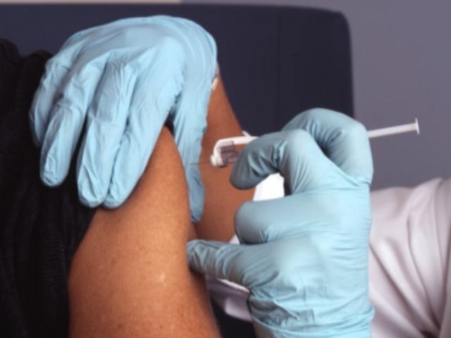 Medico effettua una vaccinazione sul braccio di una paziente
