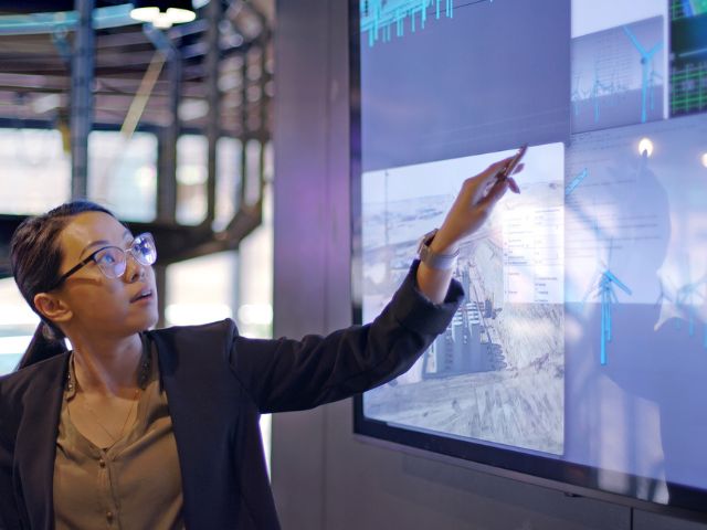 Giovane relatrice che presenta dati su energie rinnovabili e produzione energetica tradizionale.