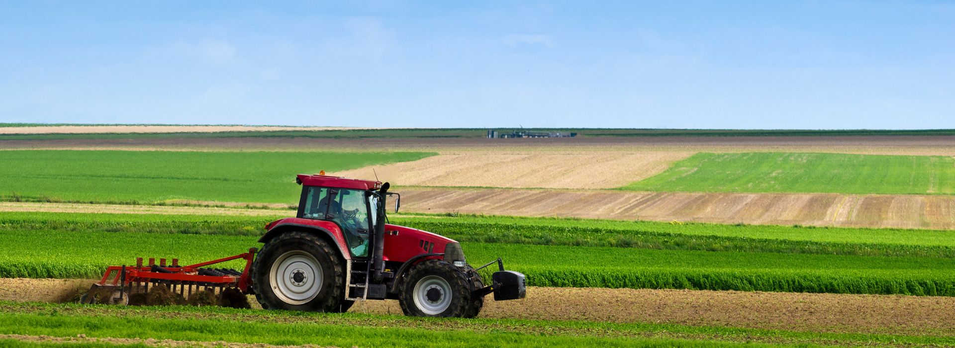 Agricoltore lavora un campo con un trattore