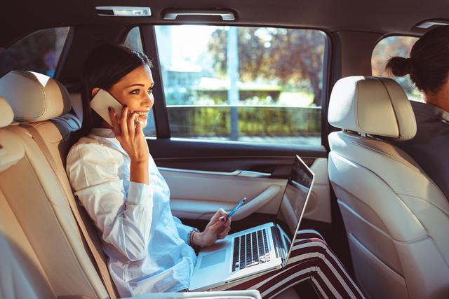 Vrouw in auto die blij is dat ze een fraudeverzekering heeft afgesloten