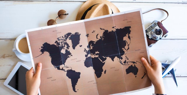Wereldkaart die een persoon vasthoudt die op vakantie gaat