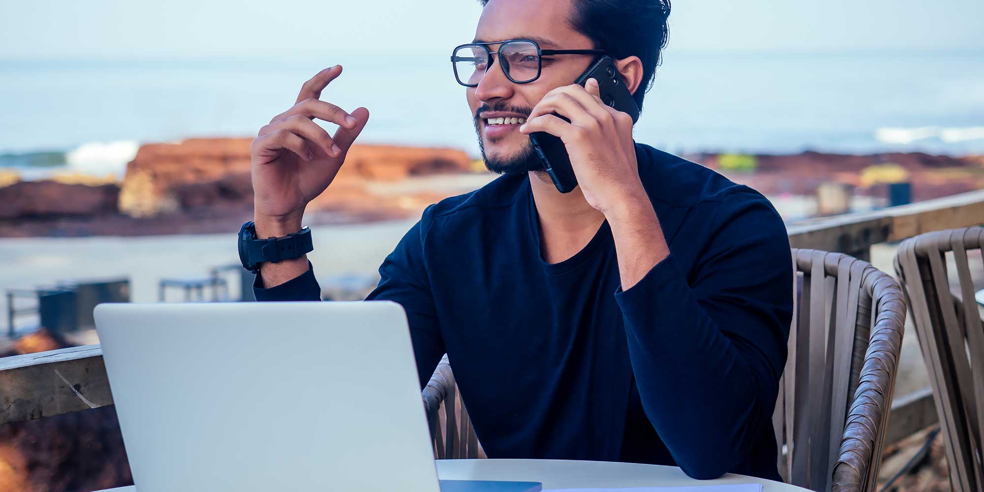 Mężczyzna pracujący przy komputerze rozmawia przez telefon