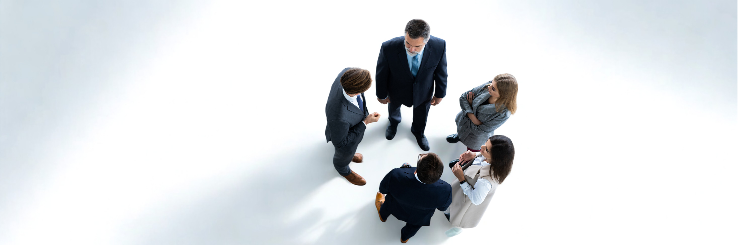 Vista-superior-de-cinco-empresarios-numa-reuniao-de-negocios-e-trabalho-em-equipa
